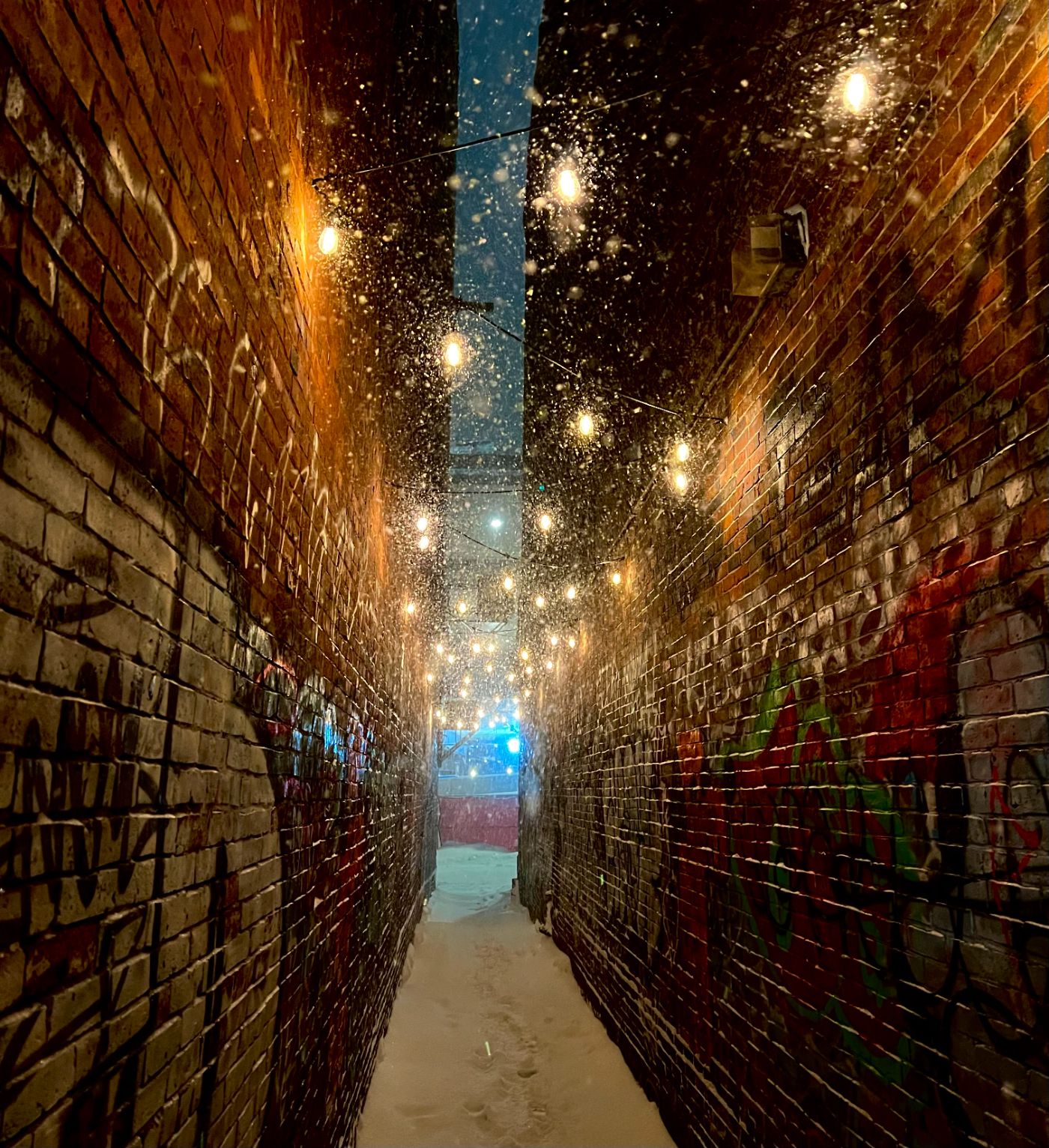 Snowy brick alley with string lights
